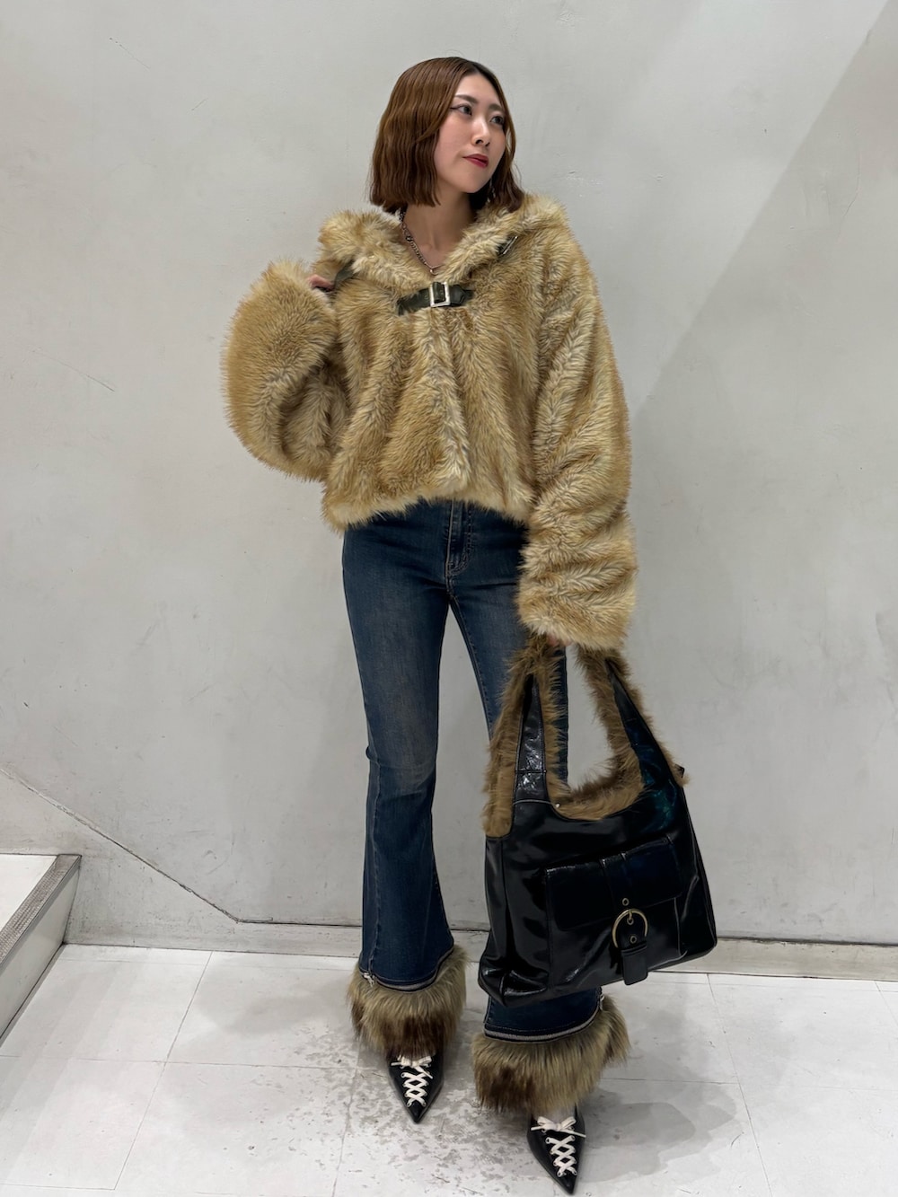 ブルー系のデニムパンツ、ブラック系のハンドバッグ、ブラック系のパンプスを着用したレディースの秋コーディネートの2枚目の写真