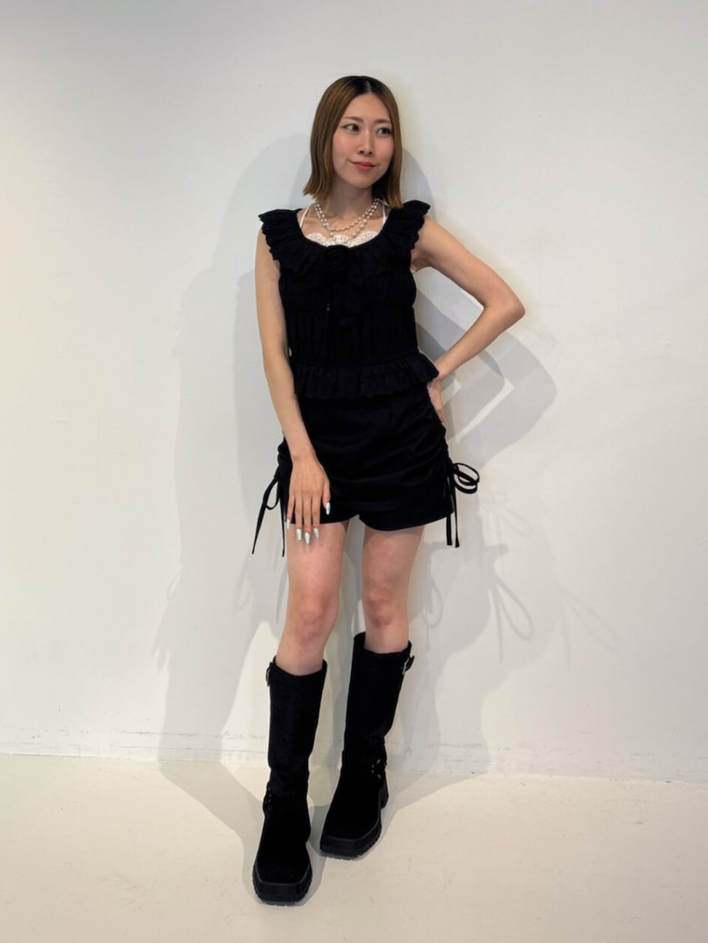 ブラック系のスカート、ブラック系のブーツ、ブラック系のシャツ/ブラウスを着用したレディースの夏コーディネートの2枚目の写真