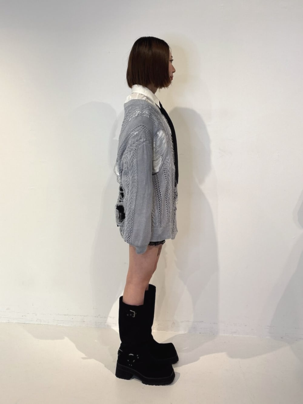 ブラック系のその他パンツ、ブラック系のブーツ、ブルー系のニット/セーターを着用したレディースの夏コーディネートの3枚目の写真