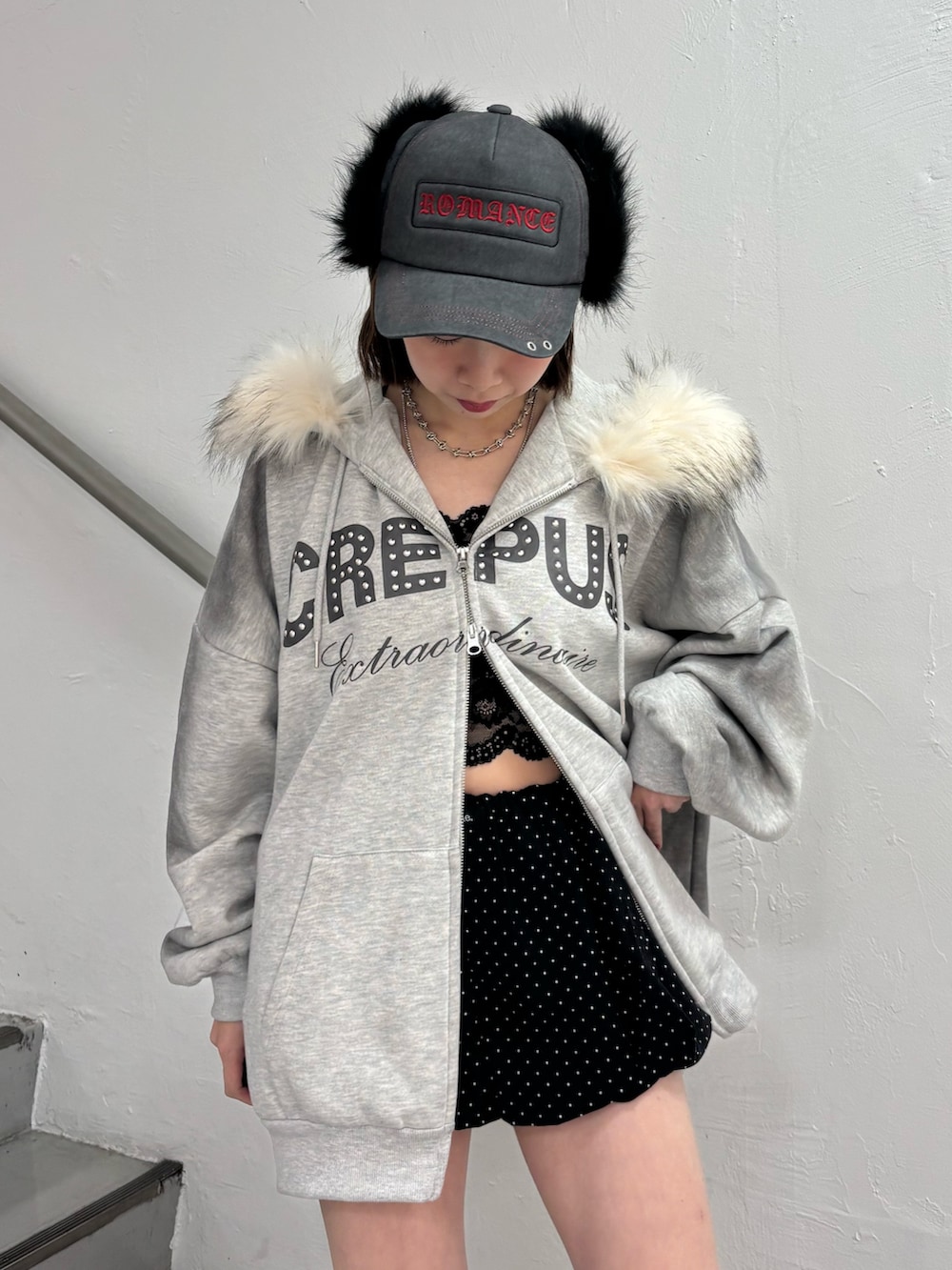 ブラック系のスカート、グレー系のパーカー、ブラック系のブーツを着用したレディースの冬コーディネートの5枚目の写真