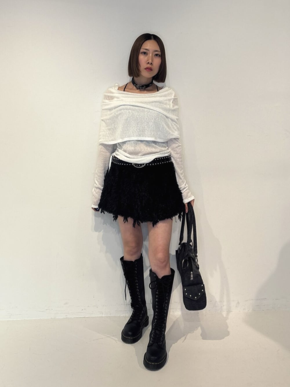 ブラック系のボストンバッグ、ホワイト系のTシャツ/カットソー、ブラック系のスカートを着用したレディースの夏コーディネートの2枚目の写真