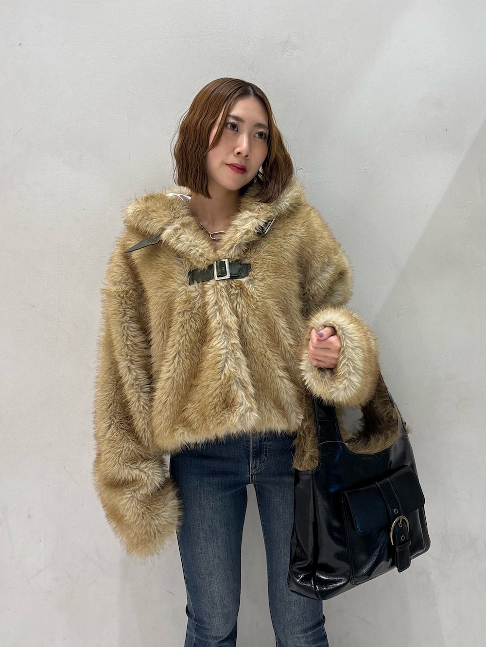 ブルー系のデニムパンツ、ブラック系のハンドバッグ、ブラック系のパンプスを着用したレディースの秋コーディネートの6枚目の写真