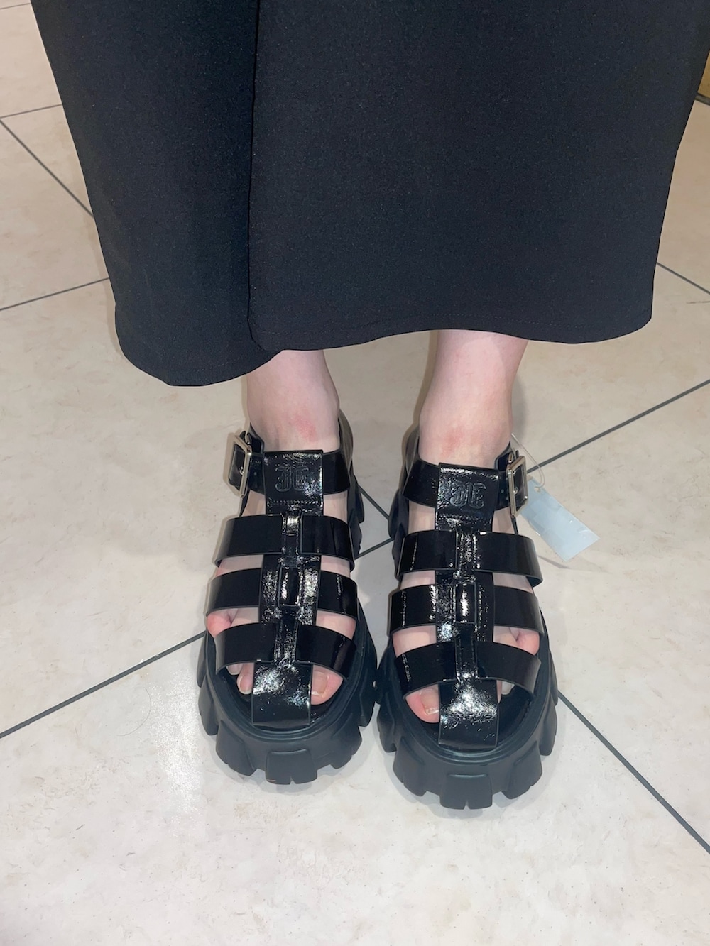 ブラック系のワンピース、ブラック系のサンダル、レッド系のブレスレットを着用したレディースの夏コーディネートの8枚目の写真