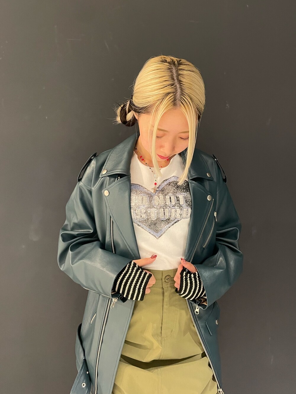 ホワイト系のTシャツ/カットソー、グリーン系のスカート、ブルー系のライダースジャケットを着用したレディースの秋コーディネートの4枚目の写真