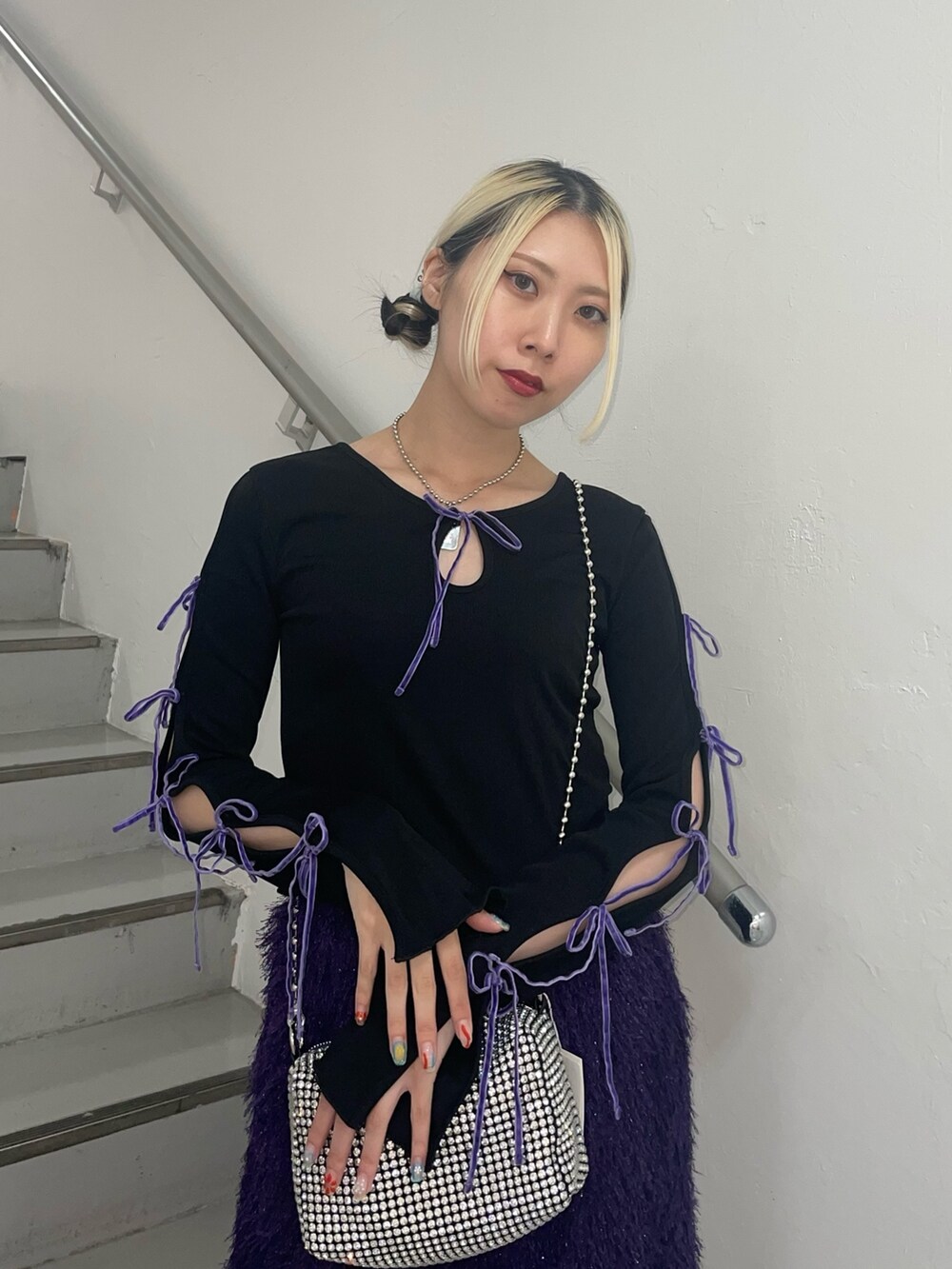 パープル系のスカート、ホワイト系のショルダーバッグ、ブラック系のTシャツ/カットソーを着用したレディースの夏コーディネートの6枚目の写真