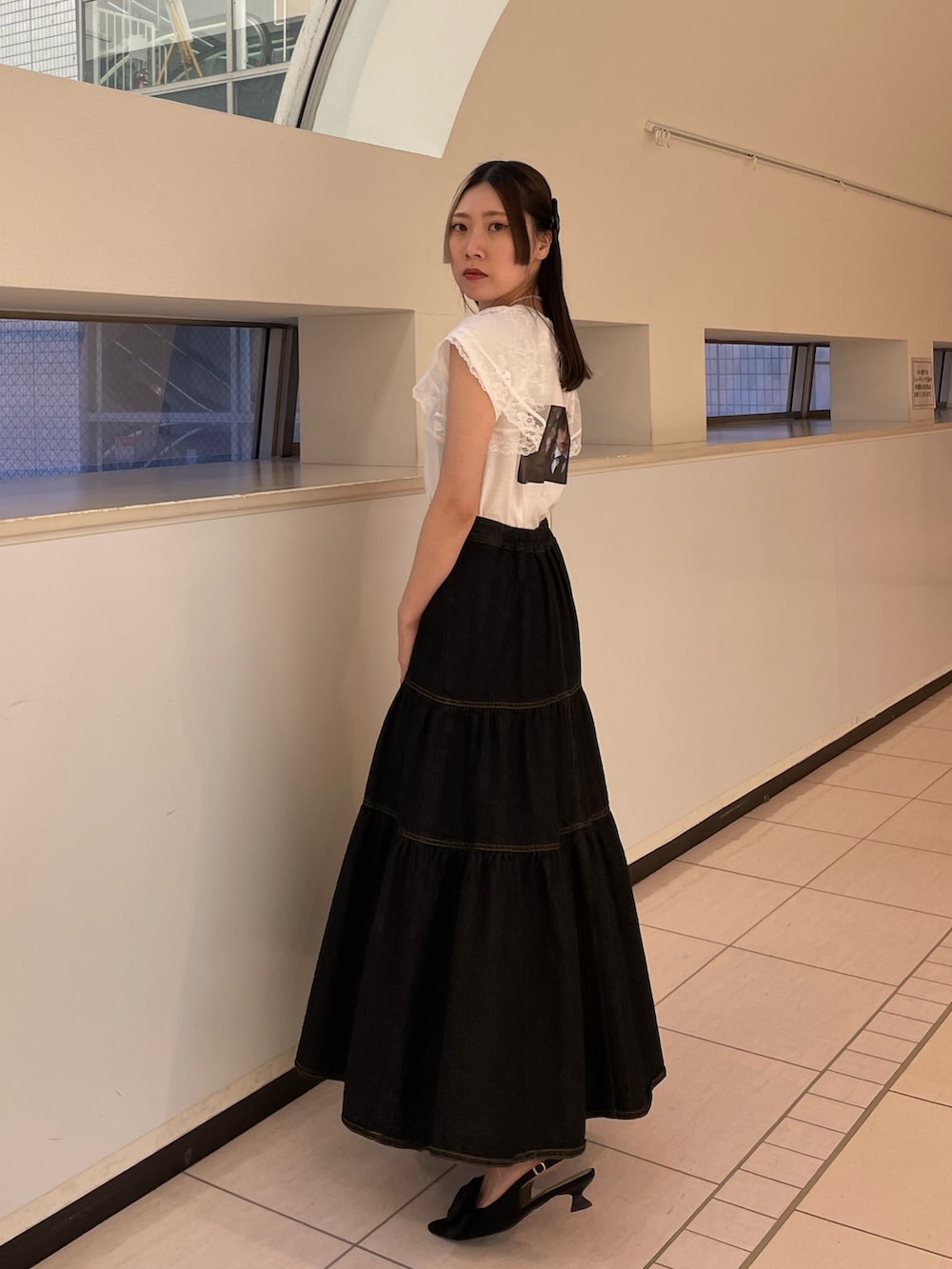 ブラック系のワンピース、ホワイト系のTシャツ/カットソー、ブラック系のパンプスを着用したレディースの春コーディネートの3枚目の写真