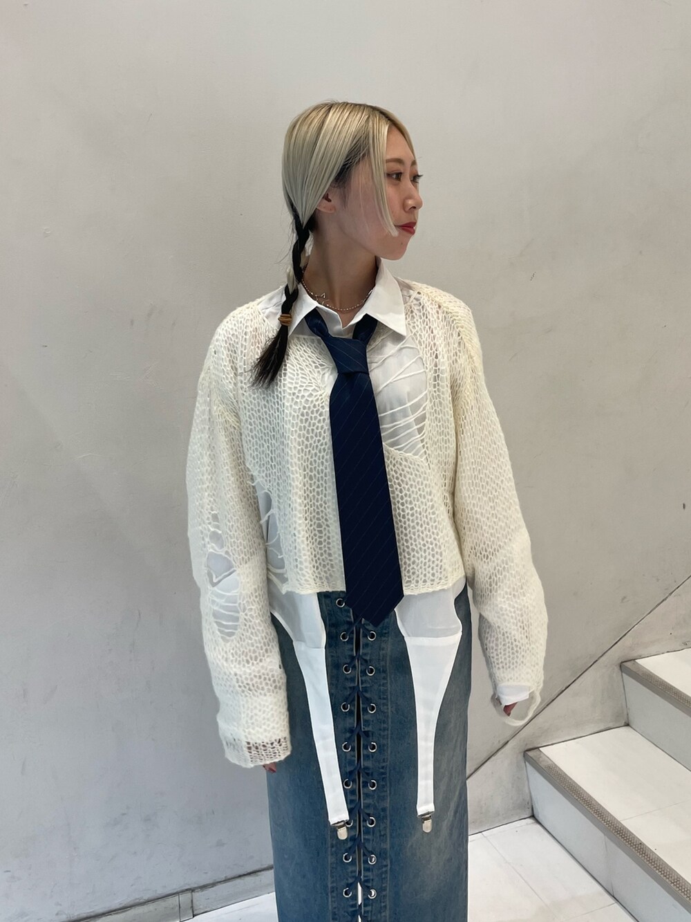 ホワイト系のニット/セーター、ホワイト系のシャツ/ブラウス、ブルー系のデニムパンツを着用したレディースの秋コーディネートの5枚目の写真