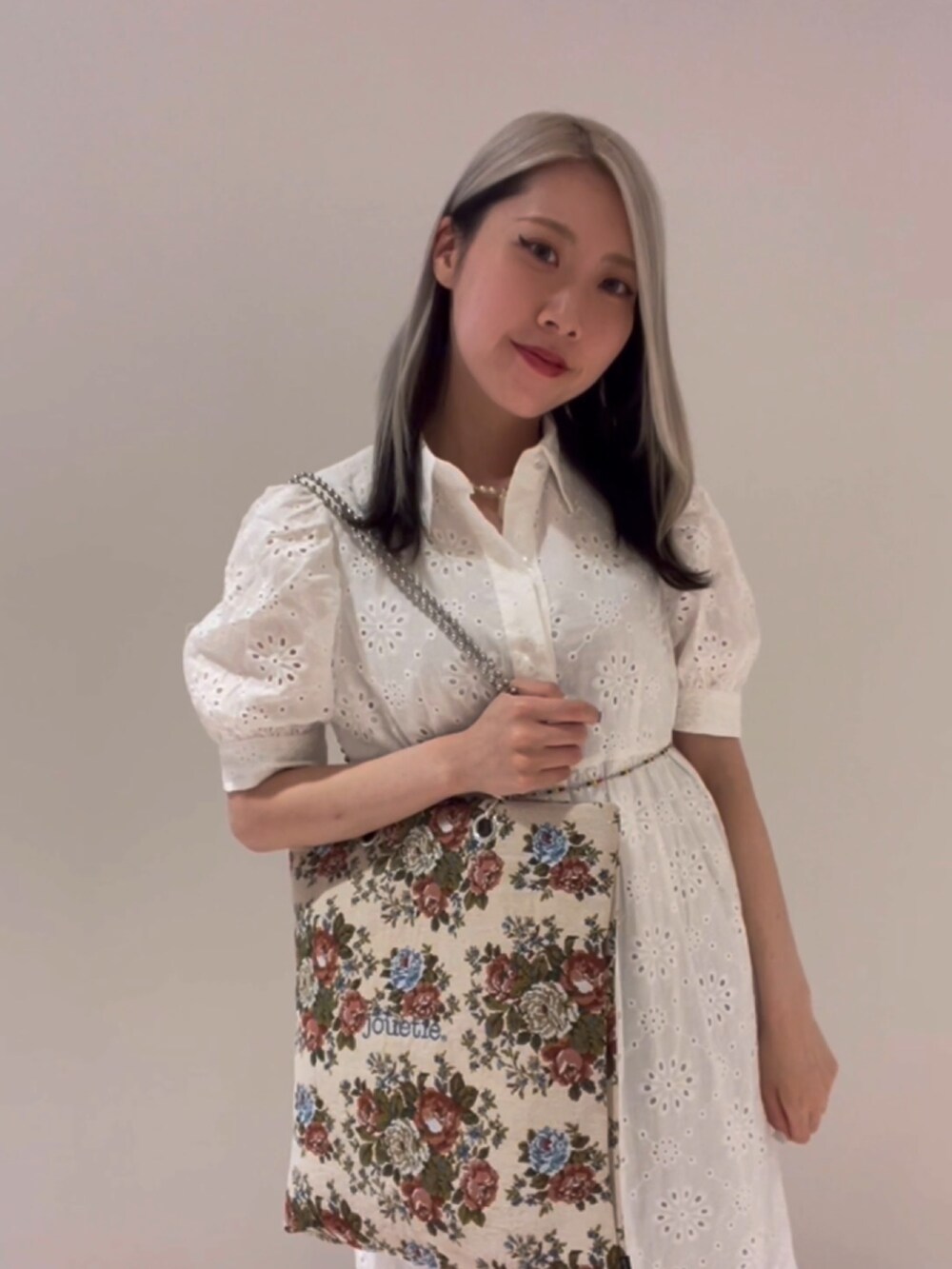 ホワイト系のワンピース、ブルー系のカーゴパンツ、その他のハンドバッグを着用したレディースの夏コーディネートの5枚目の写真