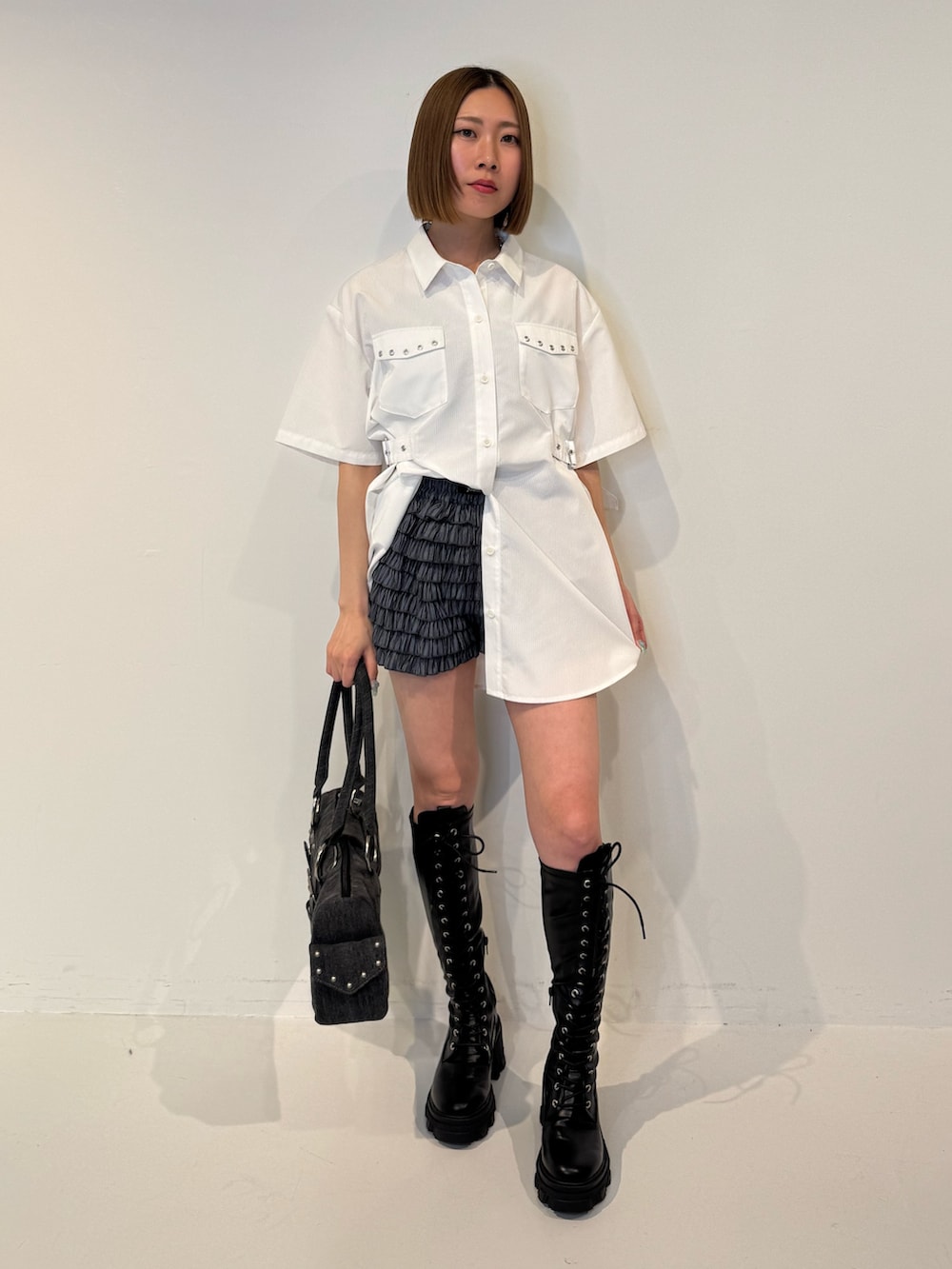 ホワイト系のシャツ/ブラウス、ブラック系のその他パンツ、ブラック系のブーツを着用したレディースの春コーディネートの2枚目の写真