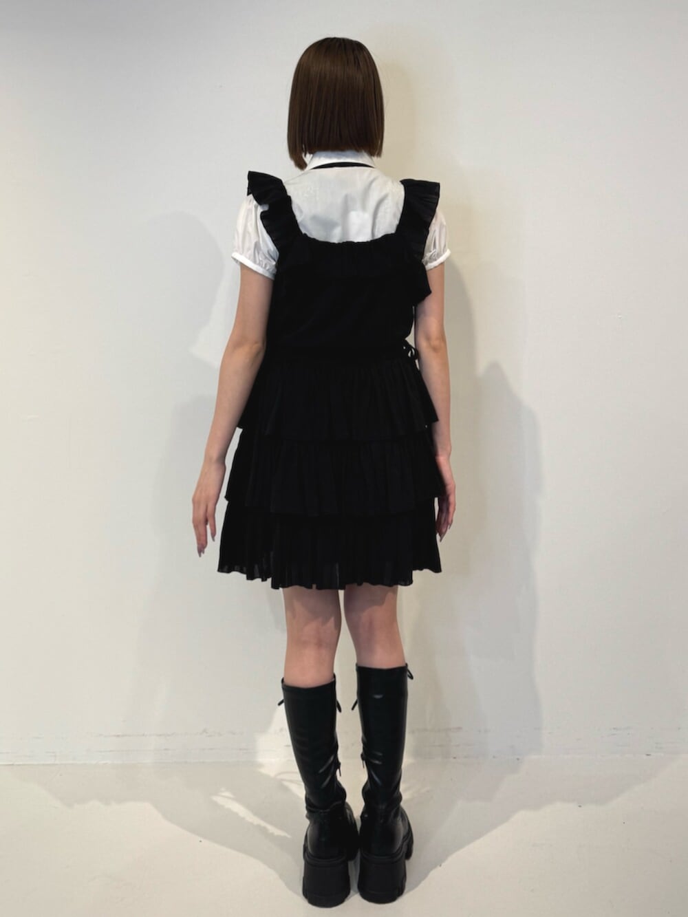 ブラック系のブーツ、ホワイト系のシャツ/ブラウス、ブラック系のネクタイを着用したレディースの春コーディネートの4枚目の写真