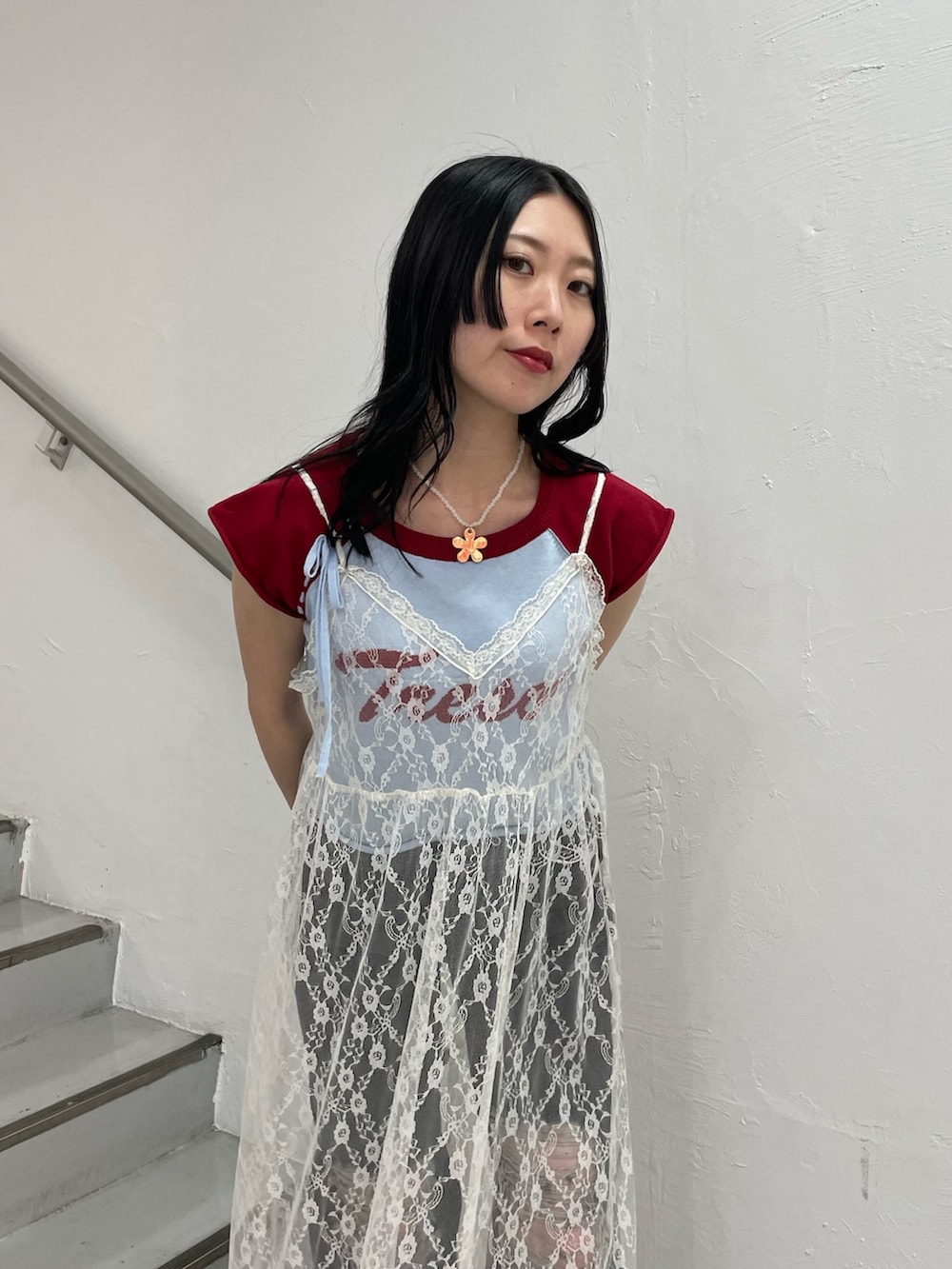 ブルー系のニット/セーター、ホワイト系のワンピース、ブラック系のデニムパンツを着用したレディースの春コーディネートの4枚目の写真