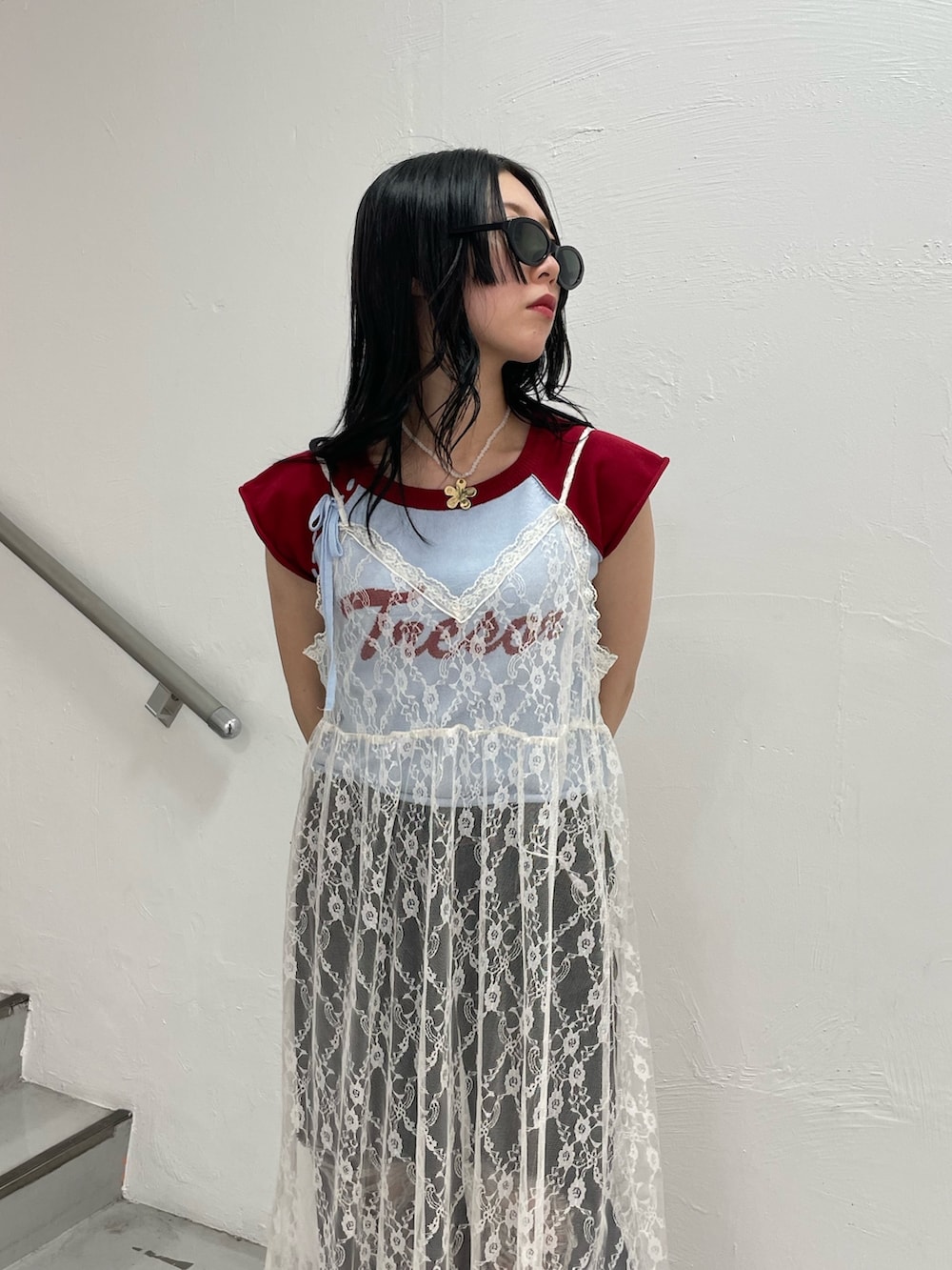 ブルー系のニット/セーター、ホワイト系のワンピース、ブラック系のデニムパンツを着用したレディースの春コーディネートの6枚目の写真