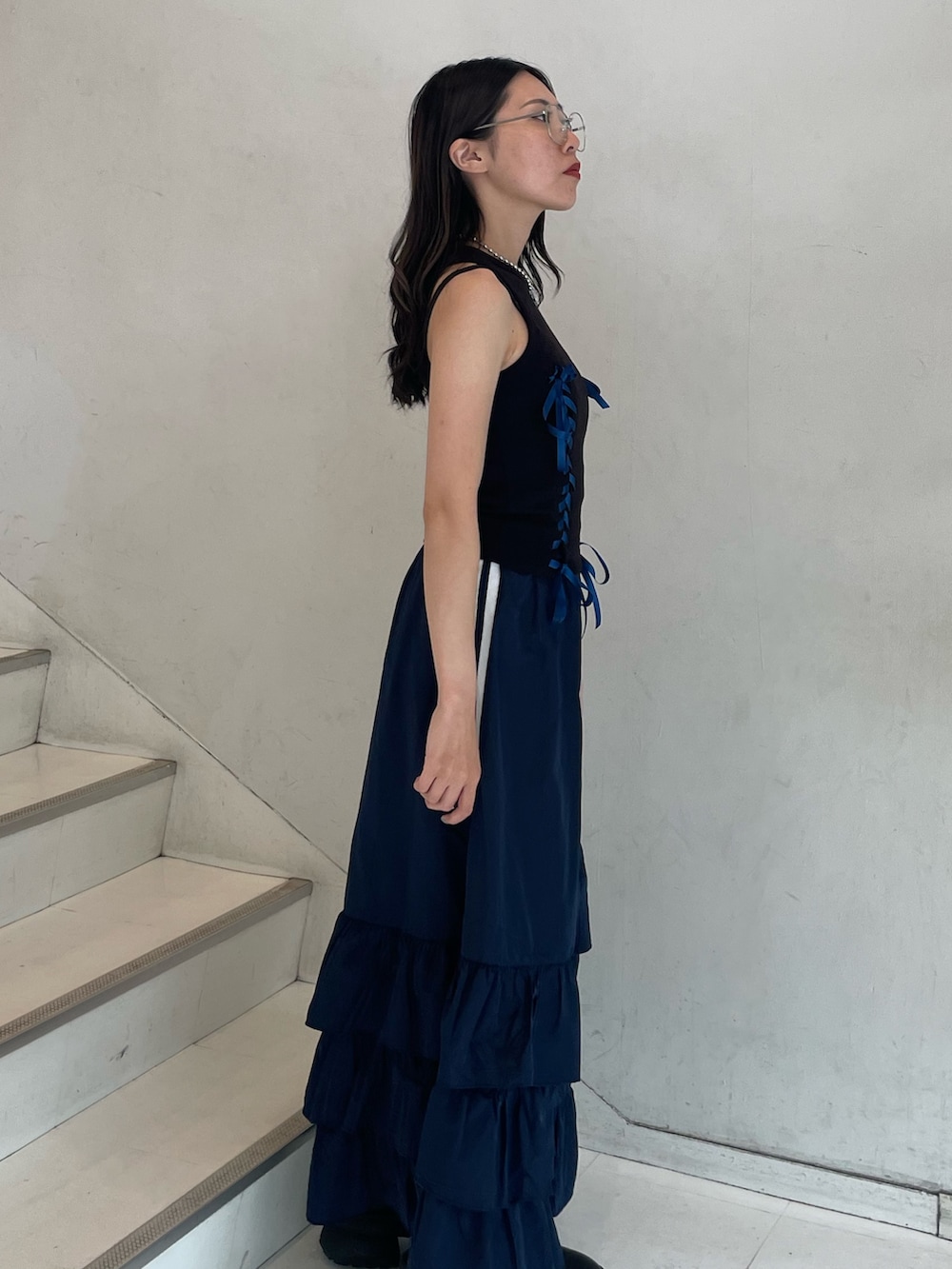 ブルー系のスカート、ブラック系のタンクトップ、ブラック系のキャミソールを着用したレディースの夏コーディネートの3枚目の写真