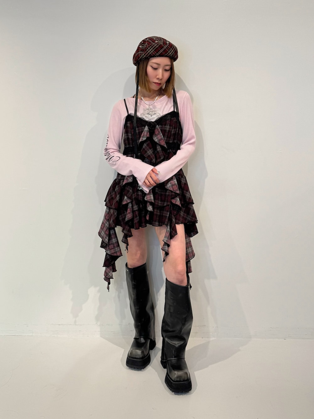 レッド系のワンピース、ブラック系のブーツ、レッド系のハンチング/ベレー帽を着用したレディースの夏コーディネートの2枚目の写真