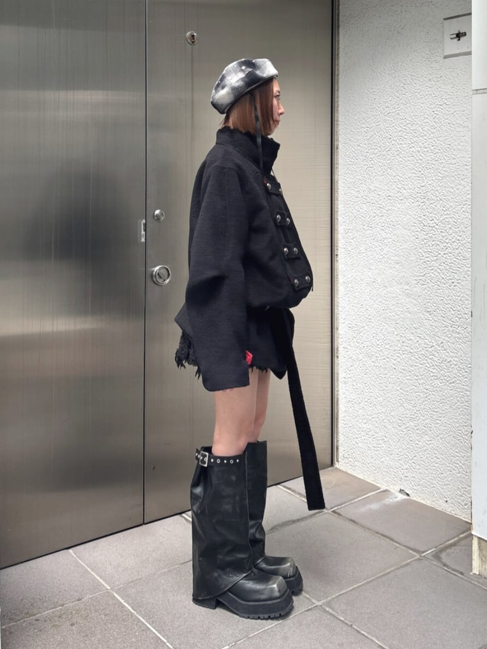 ブラック系のブーツ、ブラック系のスカート、ブラック系のその他アウターを着用したレディースの夏コーディネートの3枚目の写真