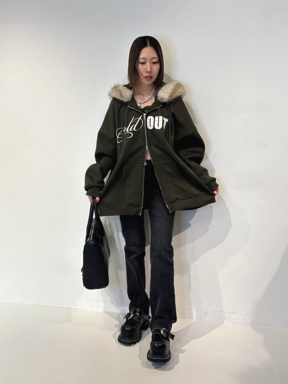 ブラック系のハンドバッグ、グリーン系のTシャツ/カットソー、ブラック系のその他パンツを着用したレディースの夏コーディネートの2枚目の写真