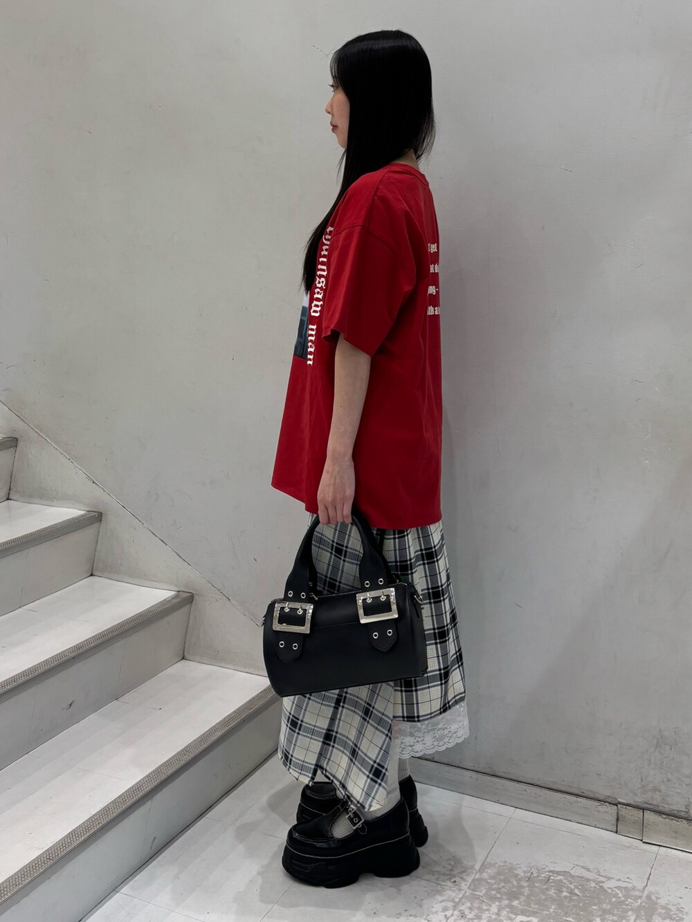 レッド系のTシャツ/カットソー、ホワイト系のスカート、ブラック系のボストンバッグを着用したレディースの春コーディネートの3枚目の写真