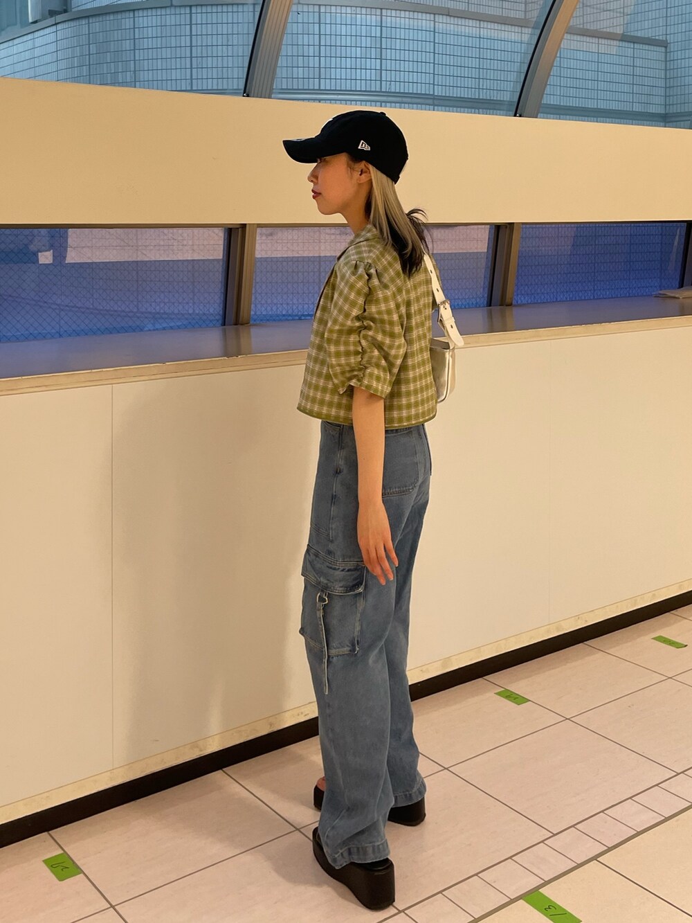 ブルー系のカーゴパンツ、グリーン系のテーラードジャケット、シルバー系のハンドバッグを着用したレディースの春コーディネートの4枚目の写真