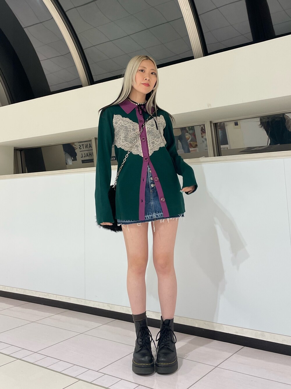 グリーン系のカーディガン/ボレロ、ブルー系のデニムパンツ、ブラック系のハンドバッグを着用したレディースの冬コーディネートの2枚目の写真