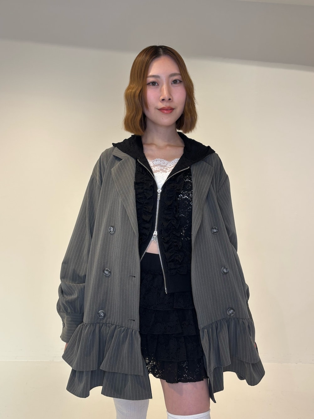 グレー系のワンピース、ブラック系のスカート、ブラック系のパーカーを着用したレディースの春コーディネートの5枚目の写真