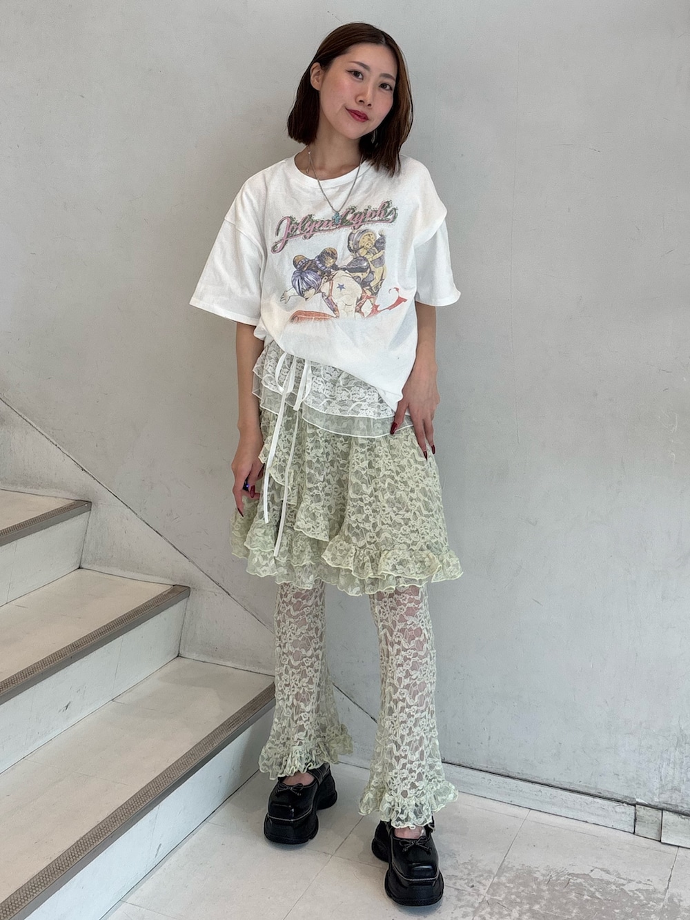 ホワイト系のTシャツ/カットソー、グリーン系のその他パンツ、ブラック系のスニーカーを着用したレディースの冬コーディネートの2枚目の写真