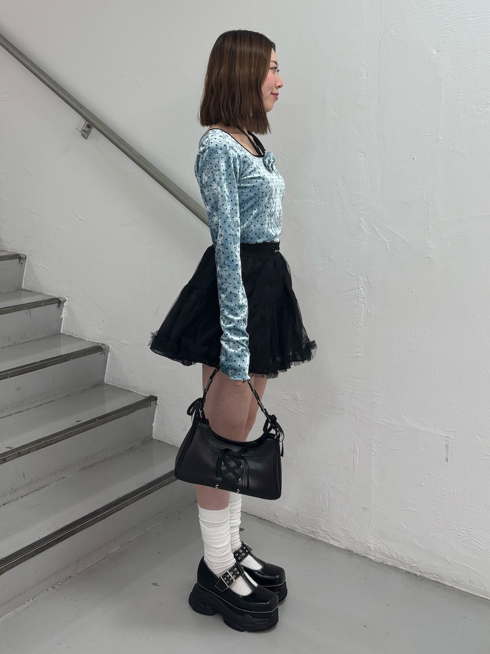 レッド系のスカート、ブルー系のTシャツ/カットソー、ブラック系のローファーを着用したレディースの冬コーディネートの3枚目の写真