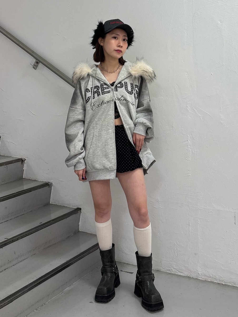 ブラック系のスカート、グレー系のパーカー、ブラック系のブーツを着用したレディースの冬コーディネートの2枚目の写真