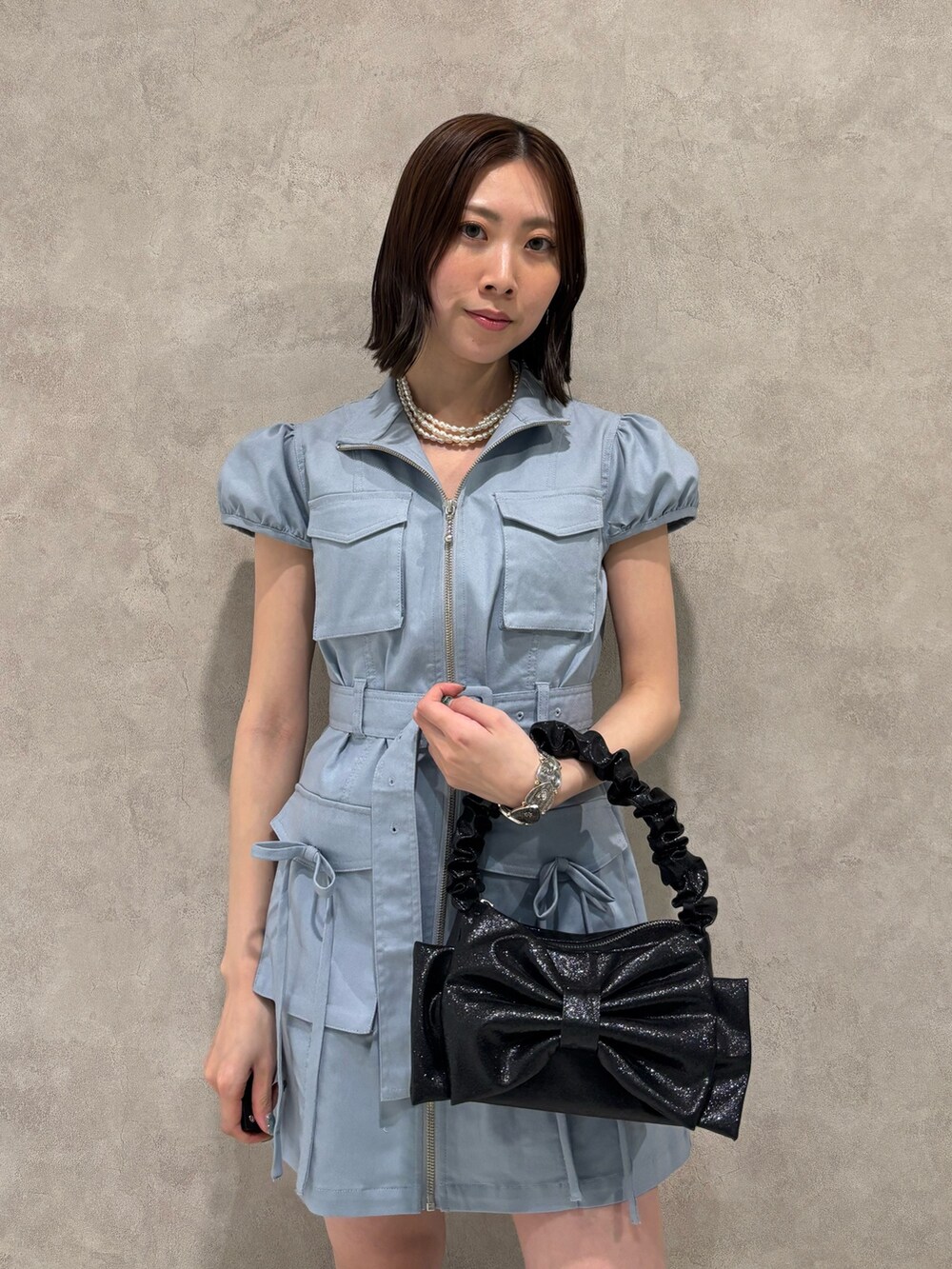 ブルー系のワンピース、ブラック系のハンドバッグ、ブラック系のローファーを着用したレディースの春コーディネートの6枚目の写真