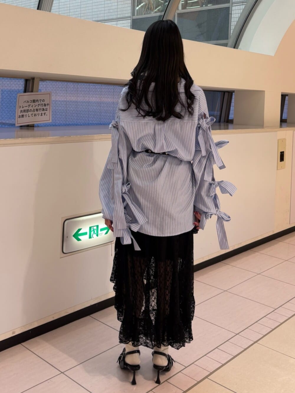 ブラック系のスカート、ブルー系のシャツ/ブラウス、ブラック系のパンプスを着用したレディースの冬コーディネートの5枚目の写真