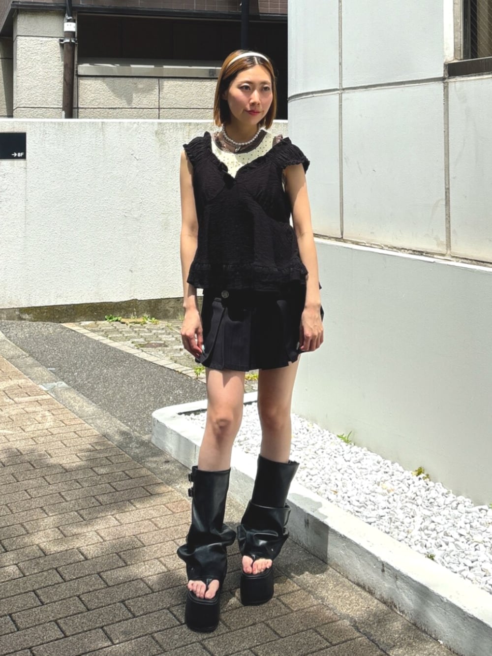ブラック系のサンダル、ブラック系のシャツ/ブラウス、ブラック系のスカートを着用したレディースの夏コーディネートの2枚目の写真
