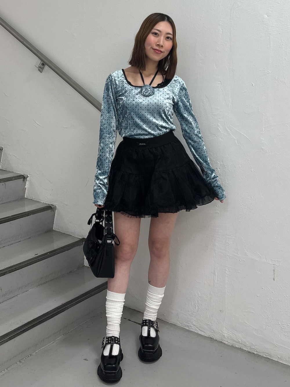 レッド系のスカート、ブルー系のTシャツ/カットソー、ブラック系のローファーを着用したレディースの冬コーディネートの2枚目の写真