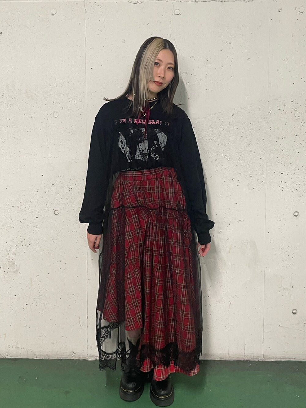 レッド系のスカート、ブラック系のワンピース、レッド系のネックレスを着用したレディースの冬コーディネートの2枚目の写真