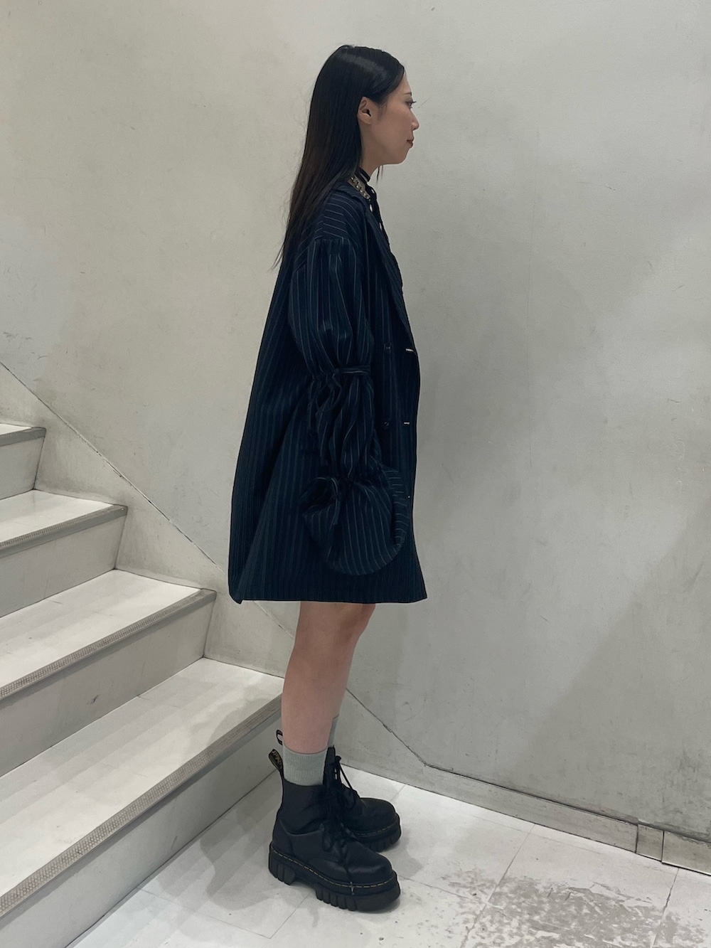 ブラック系のTシャツ/カットソー、ブルー系のテーラードジャケット、ブルー系のスカートを着用したレディースの秋コーディネートの3枚目の写真