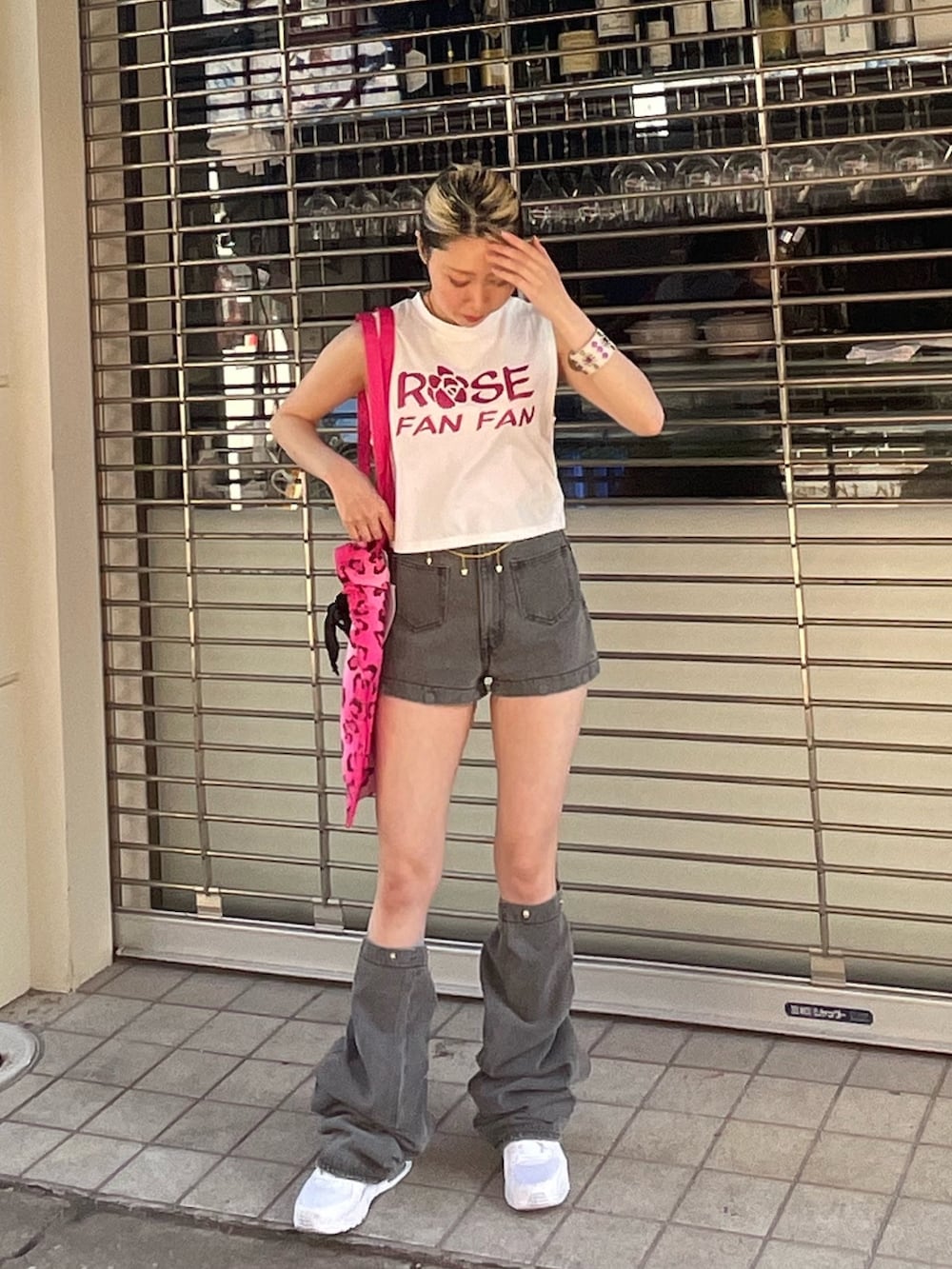 ホワイト系のタンクトップ、ブラック系のデニムパンツ、ピンク系のトートバッグを着用したレディースの春コーディネートの3枚目の写真