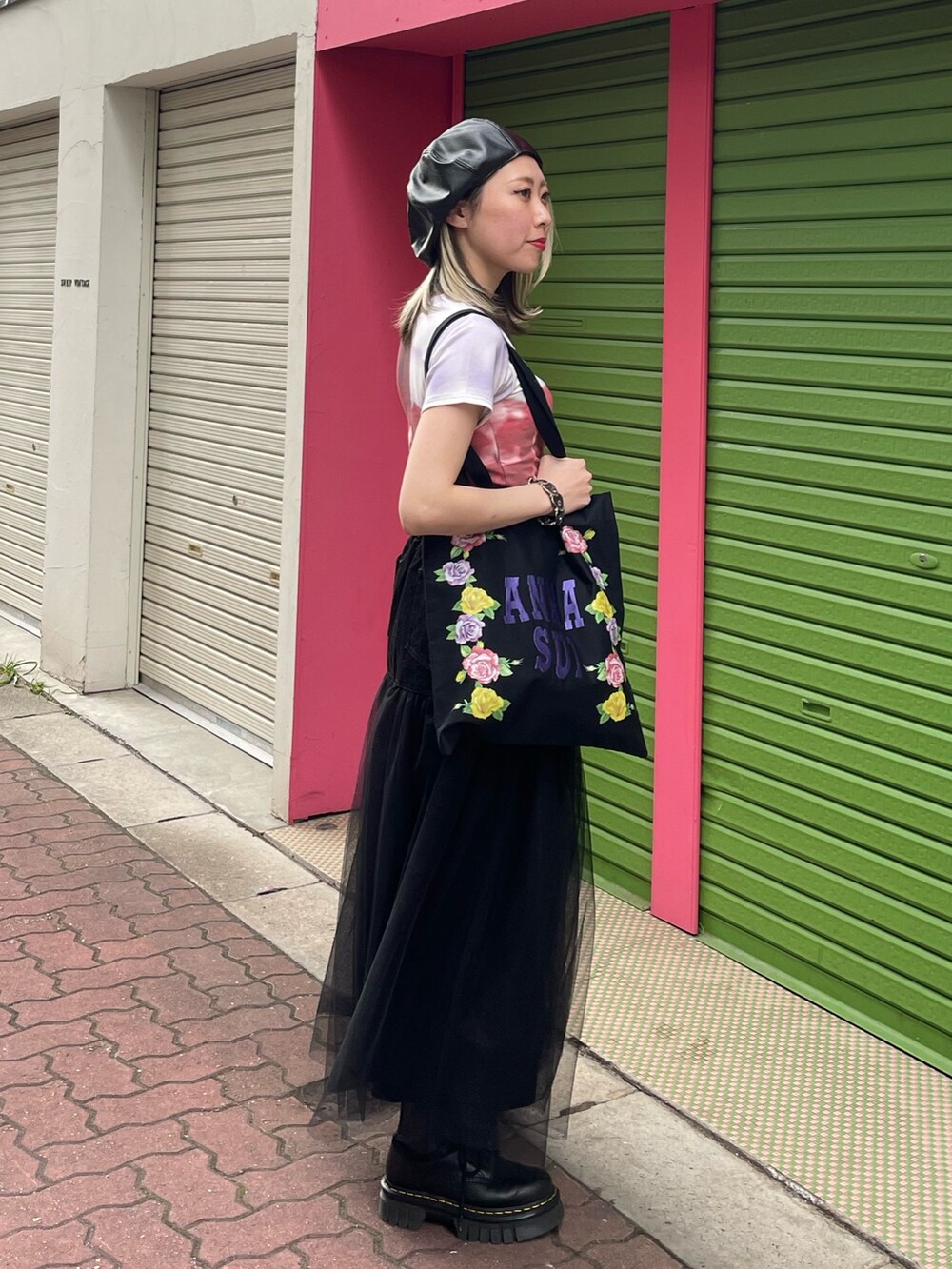 ブラック系のスカート、ブラック系のトートバッグ、パープル系のTシャツ/カットソーを着用したレディースの春コーディネートの3枚目の写真