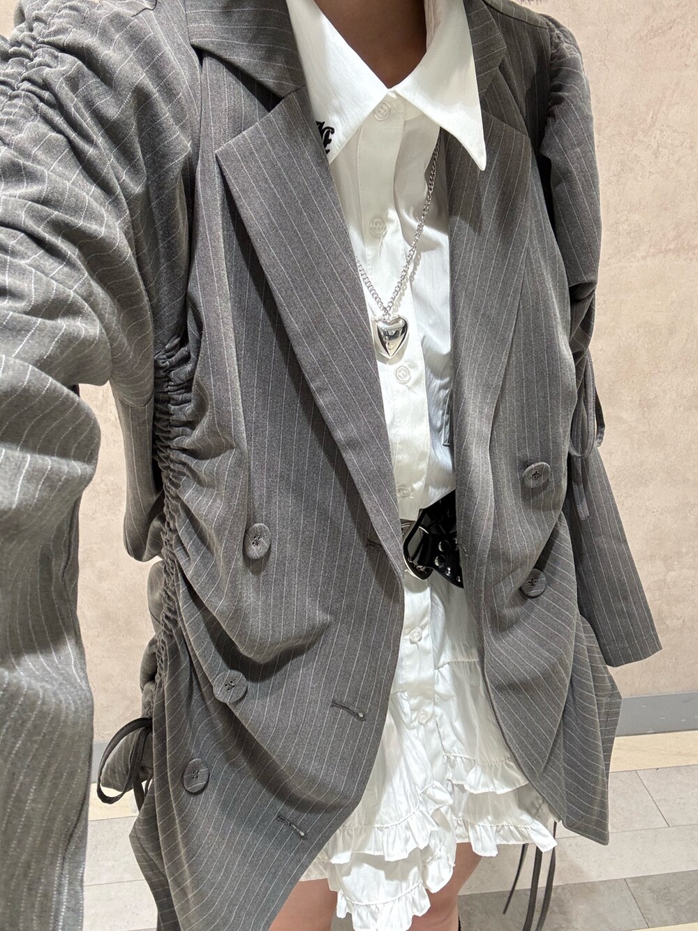 ホワイト系のワンピース、ブラック系のパンプス、グレー系のテーラードジャケットを着用したレディースの夏コーディネートの10枚目の写真