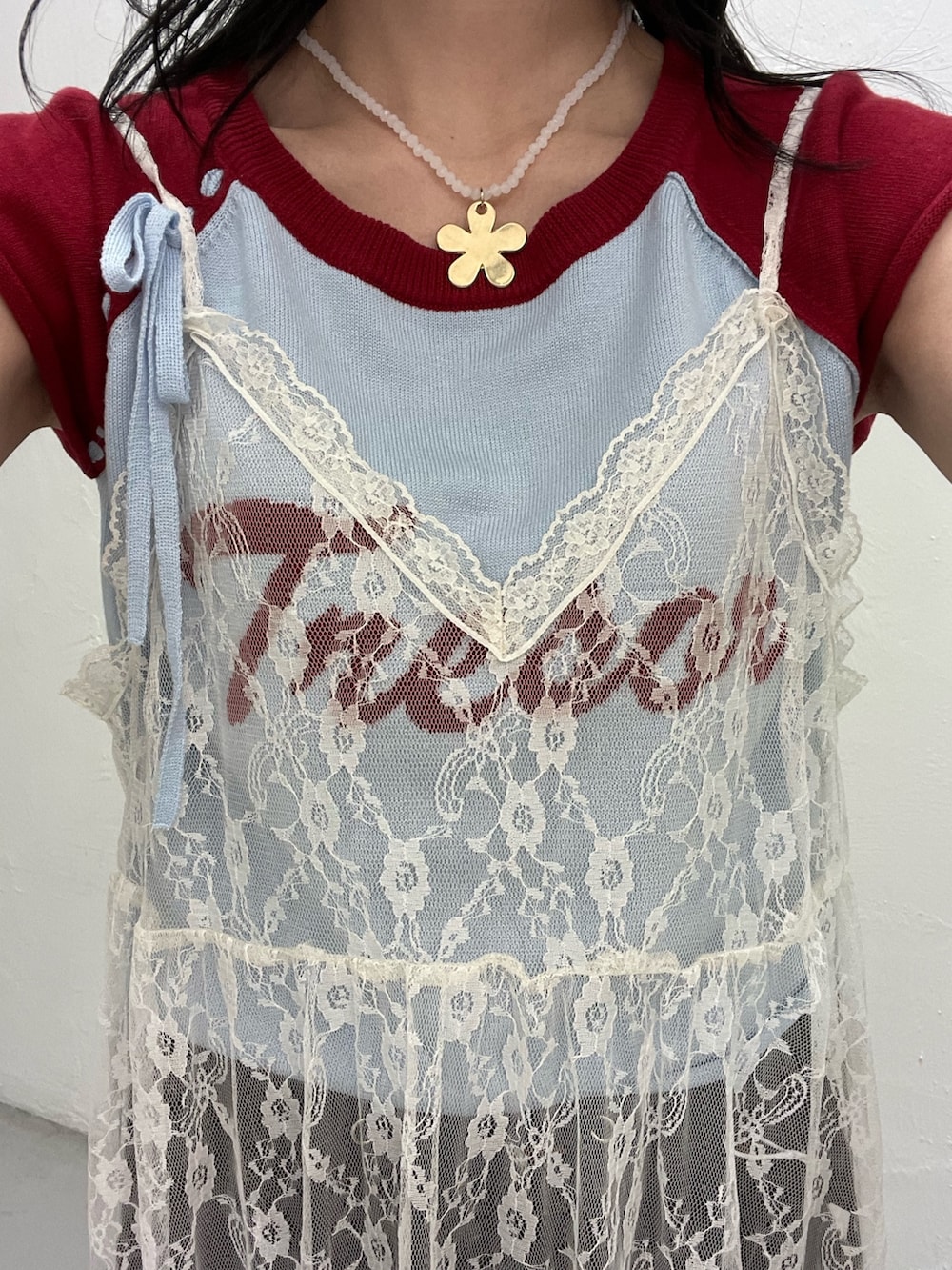 ブルー系のニット/セーター、ホワイト系のワンピース、ブラック系のデニムパンツを着用したレディースの春コーディネートの8枚目の写真