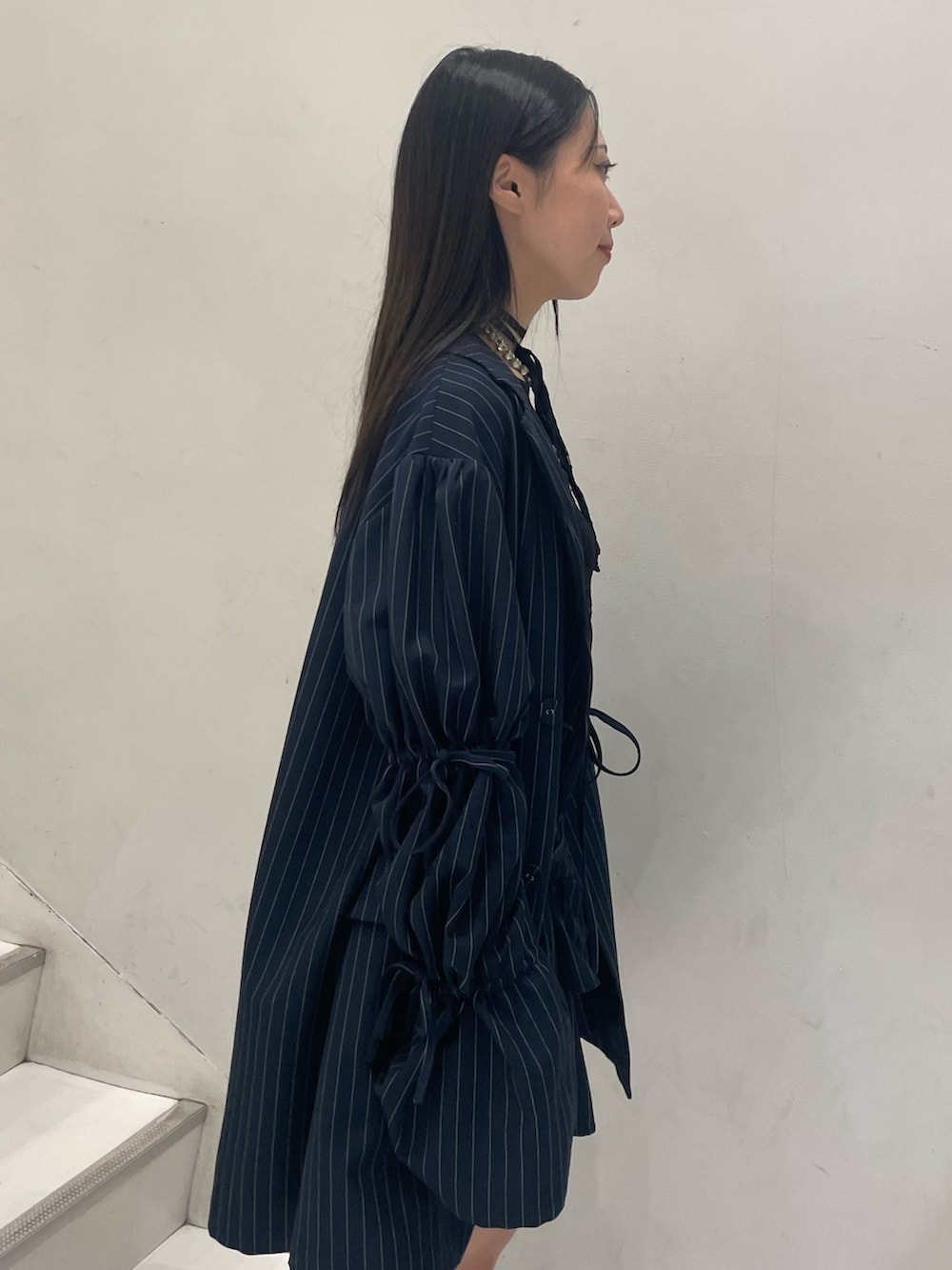 ブラック系のTシャツ/カットソー、ブルー系のテーラードジャケット、ブルー系のスカートを着用したレディースの秋コーディネートの7枚目の写真