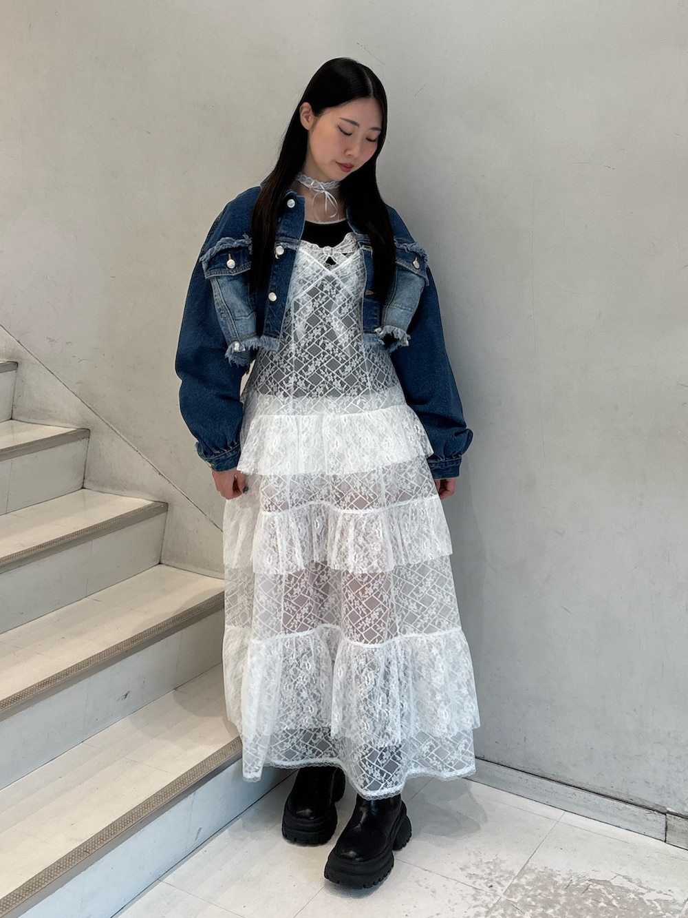 ホワイト系のワンピース、ブルー系のデニムジャケット、ブラック系のTシャツ/カットソーを着用したレディースの春コーディネートの2枚目の写真