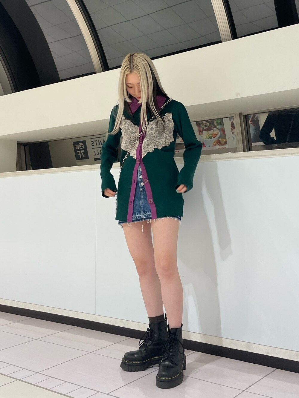 グリーン系のカーディガン/ボレロ、ブルー系のデニムパンツ、ブラック系のハンドバッグを着用したレディースの冬コーディネートの4枚目の写真