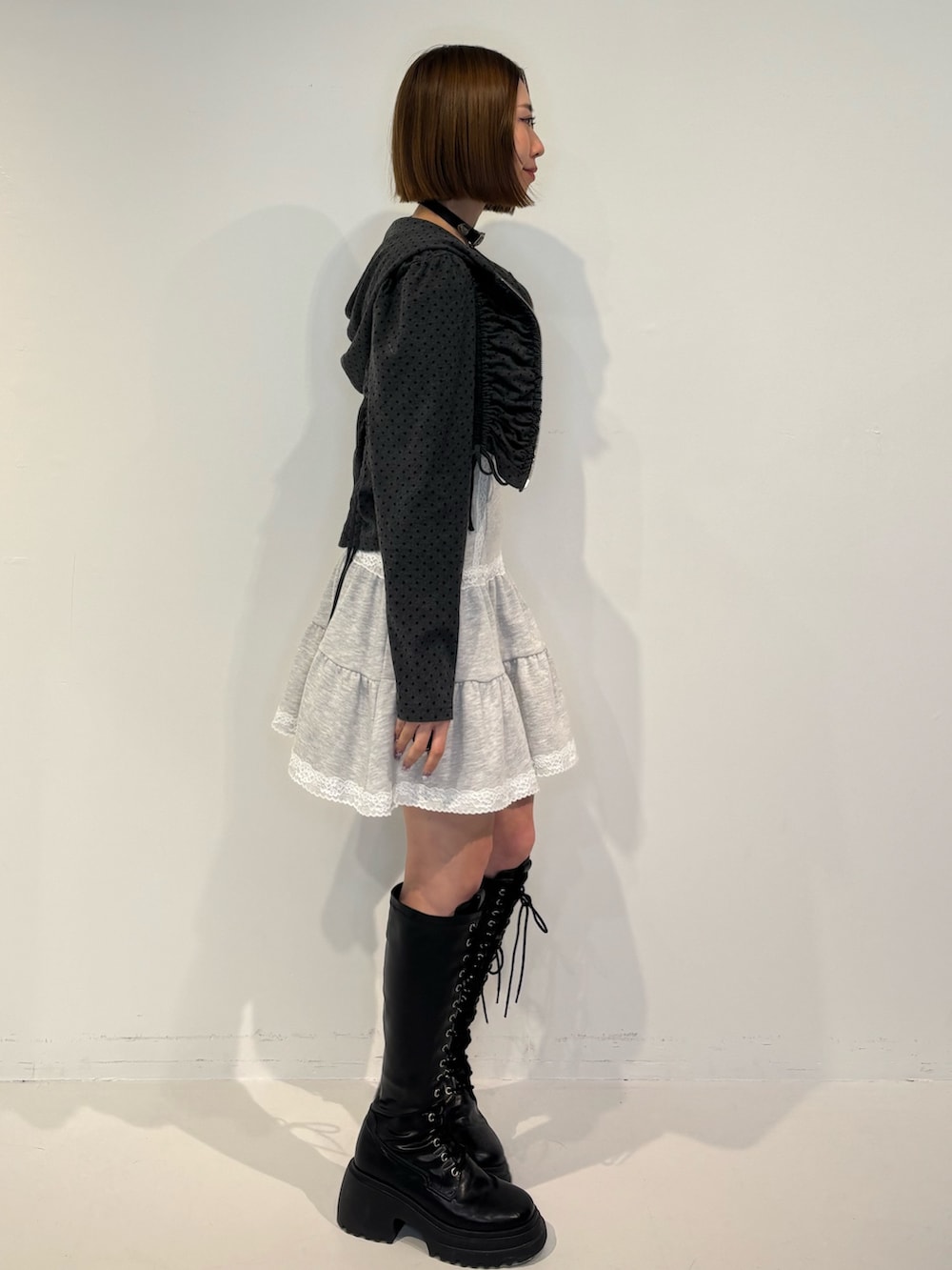 ブラック系のパーカー、グレー系のワンピース、ブラック系のブーツを着用したレディースの冬コーディネートの3枚目の写真