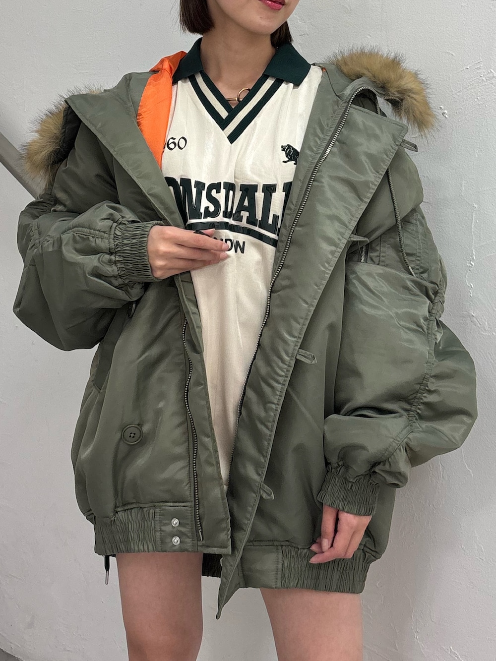 ホワイト系のTシャツ/カットソー、ホワイト系のスカート、グリーン系のブルゾンを着用したレディースの秋コーディネートの9枚目の写真