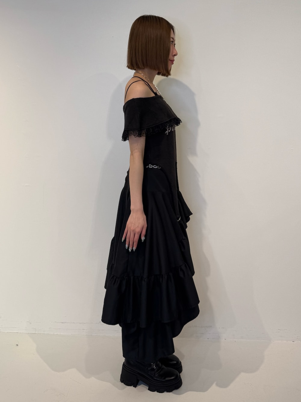 ブラック系のTシャツ/カットソー、ブラック系のスカート、ブラック系のブーツを着用したレディースの春コーディネートの2枚目の写真
