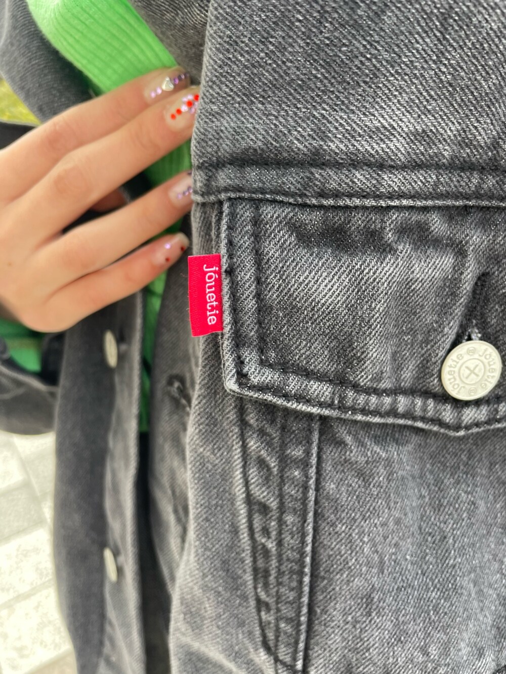 ブラック系のスカート、グリーン系のTシャツ/カットソー、ブラック系のデニムジャケットを着用したレディースの春コーディネートの10枚目の写真