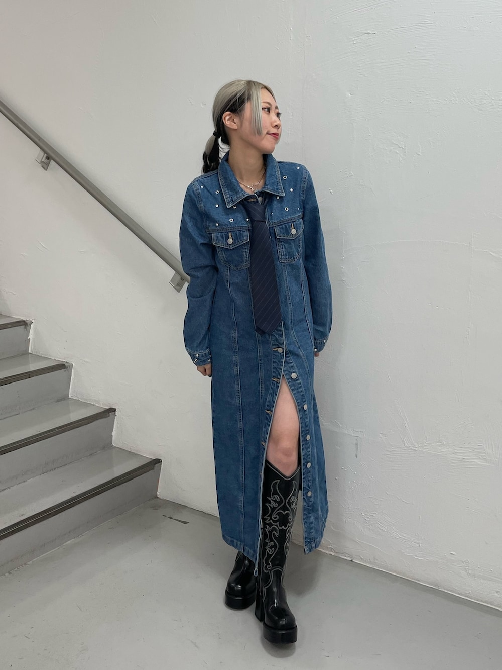 ブルー系のワンピース、ブラック系のブーツ、ブルー系のネクタイを着用したレディースの冬コーディネートの3枚目の写真