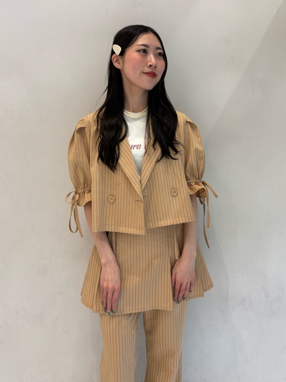 ベージュ系のテーラードジャケット、ベージュ系のその他パンツ、ベージュ系のスカートを着用したレディースの冬コーディネートの6枚目の写真