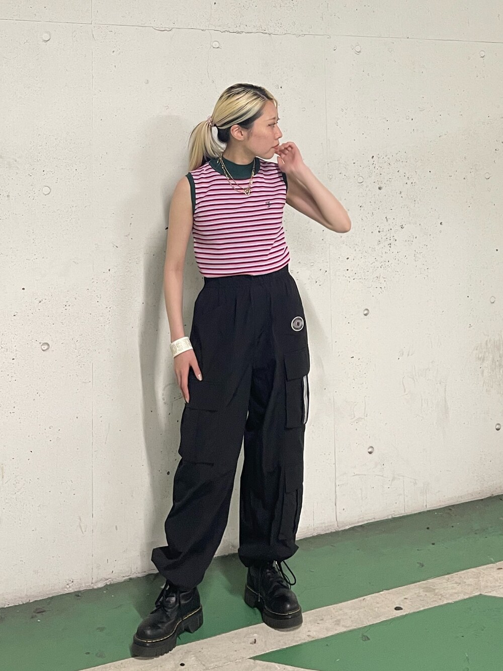 ブラック系のカーゴパンツ、ピンク系のニット/セーター、ホワイト系のブレスレットを着用したレディースの夏コーディネートの3枚目の写真