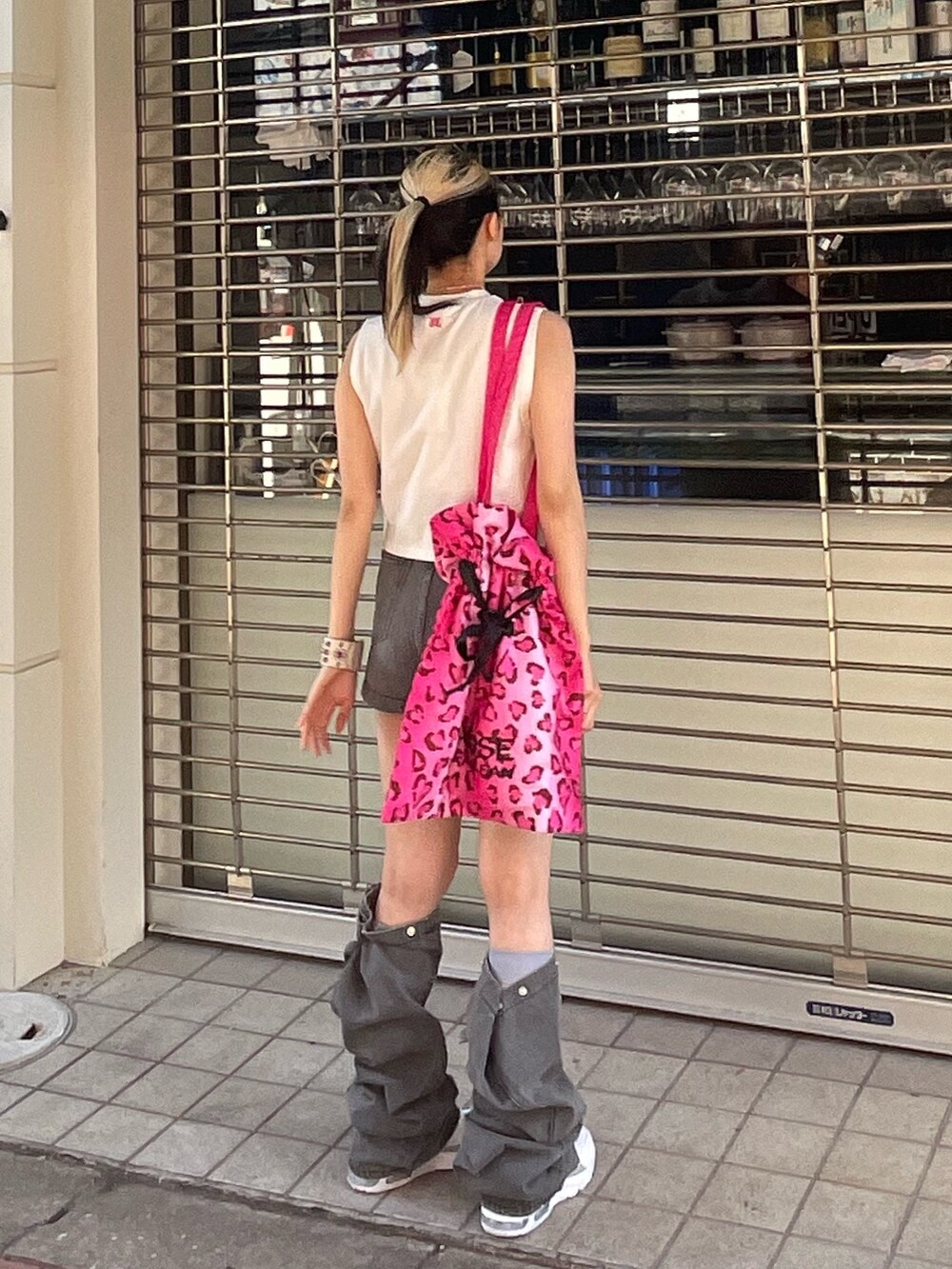 ホワイト系のタンクトップ、ブラック系のデニムパンツ、ピンク系のトートバッグを着用したレディースの春コーディネートの4枚目の写真