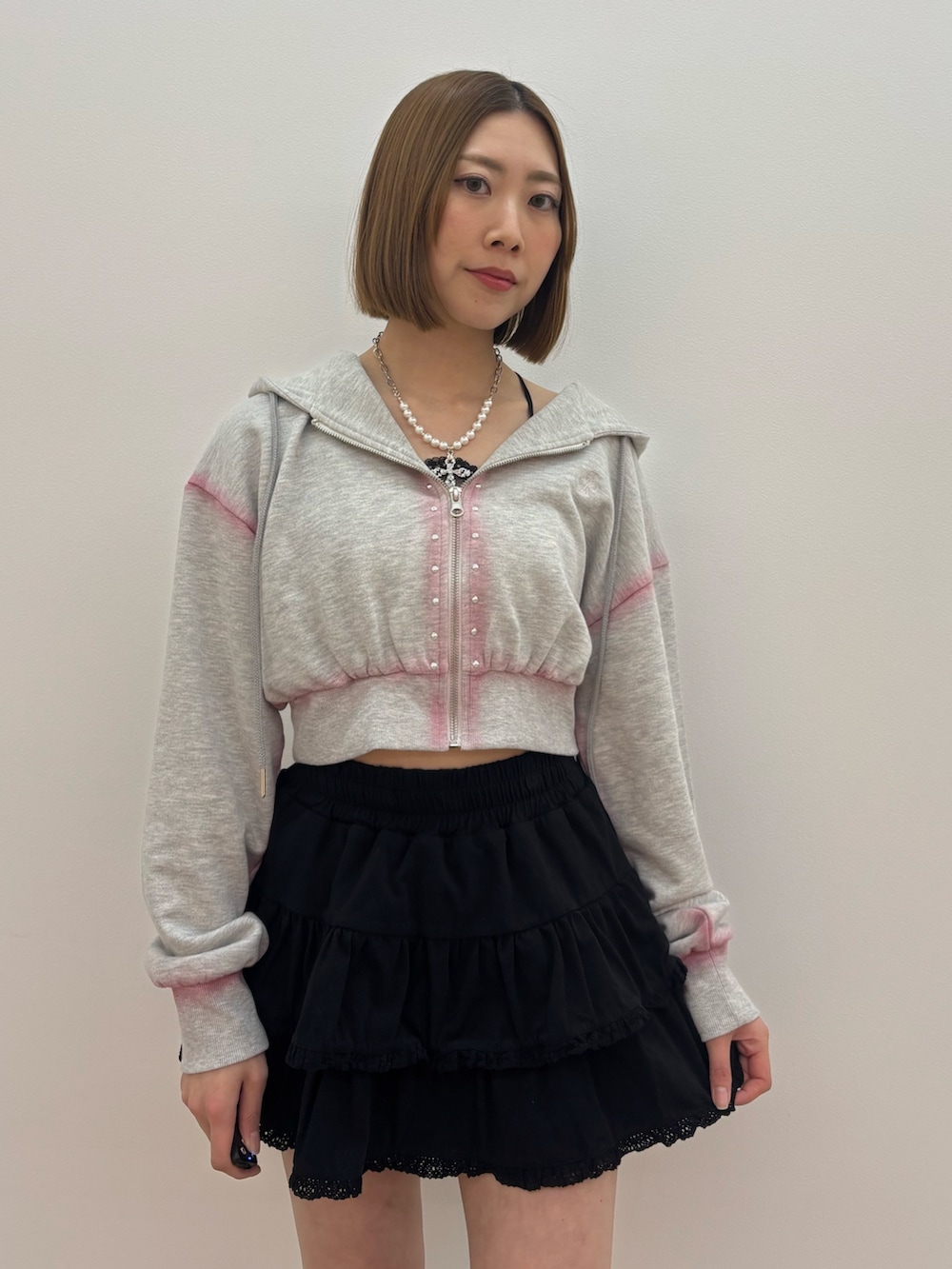 グレー系のパーカー、ブラック系のローファー、シルバー系のネックレスを着用したレディースの春コーディネートの5枚目の写真