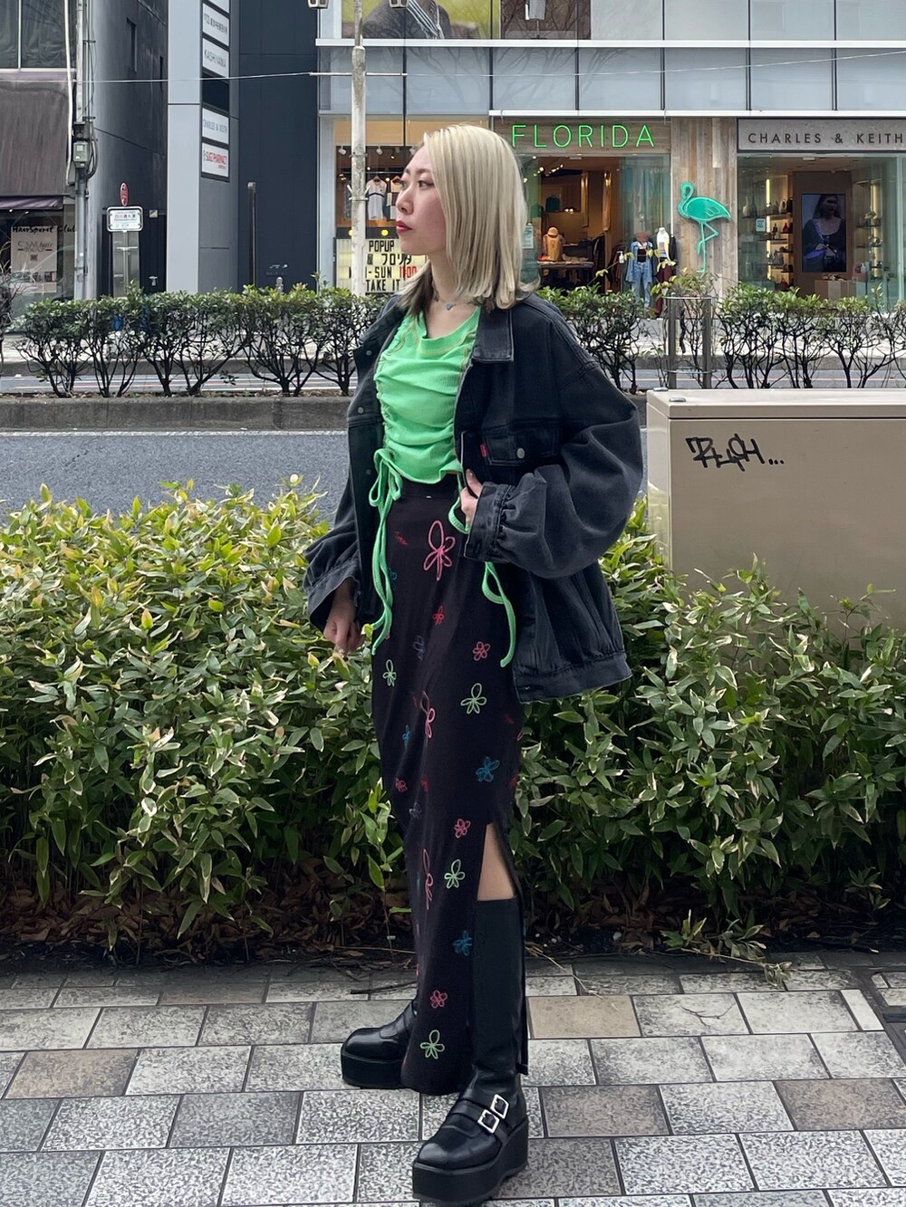 ブラック系のスカート、グリーン系のTシャツ/カットソー、ブラック系のデニムジャケットを着用したレディースの春コーディネートの4枚目の写真